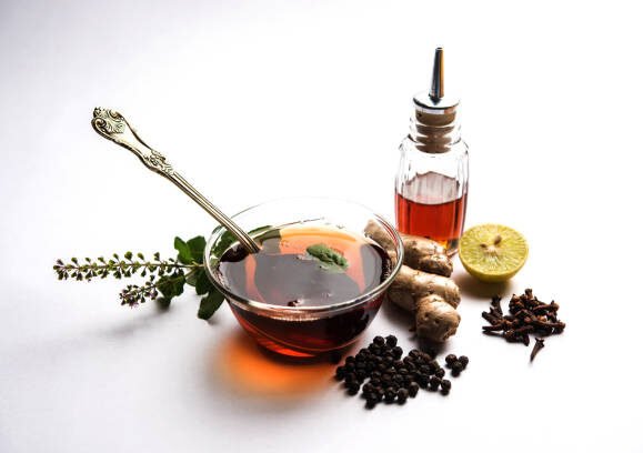 Indian Ayurvedic Kadha/Karha or health tonic for fighting seasonal infections, made using ginger, tulsi, black pepper, clove and honey. Selective focus